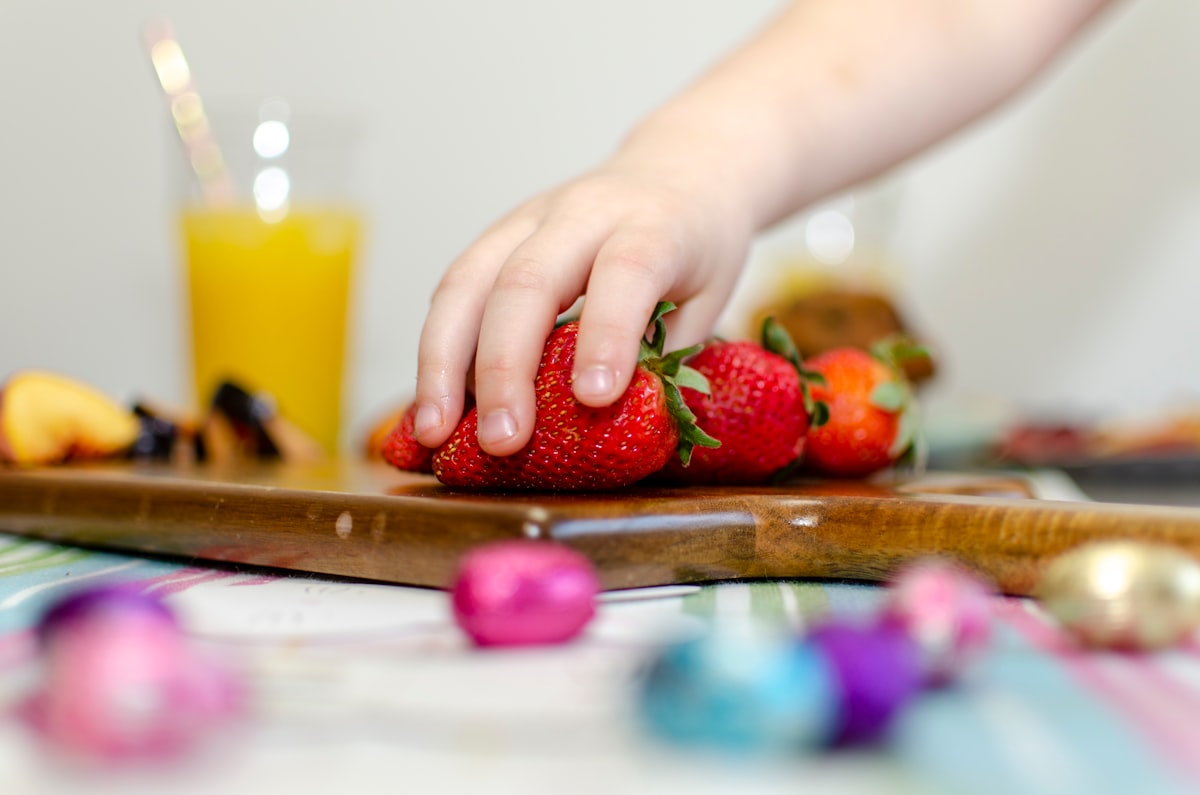 Famiglia che prepara insieme una merenda sana, bambini sorridenti aiutano in cucina
